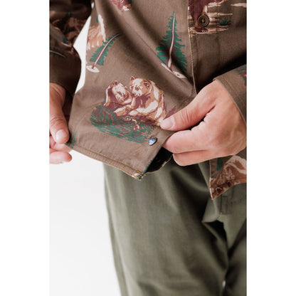 Close-up of the Kavu Westerly in Faraway Forest showing a bear print and a model adjusting the shirt.