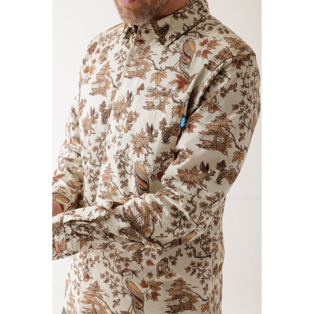 Side view of the Kavu Westerly men's shirt in Faraway Forest with a nature print and blue sleeve tag against a white background.