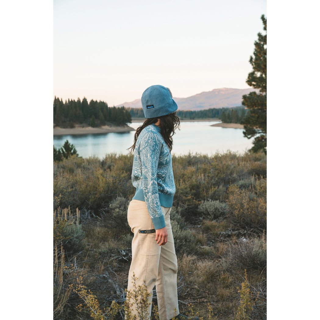 Side view of the Kavu Wood Valley in Big Bear showing a model wearing it against a lake and mountain backdrop.