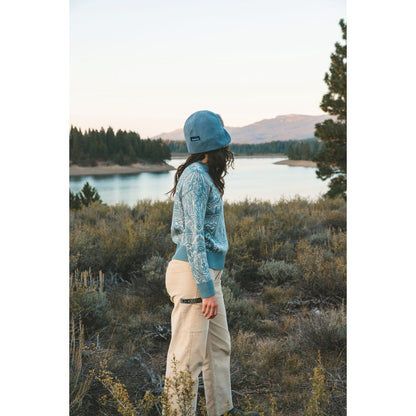 Side view of the Kavu Wood Valley in Big Bear showing a model wearing it against a lake and mountain backdrop.
