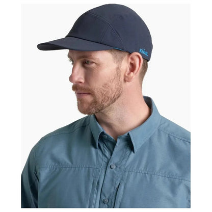 Side view of the Kuhl Breeze Cap in Pirate Blue on a model wearing a blue shirt against a white background.