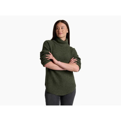 A model wearing the Kuhl Women's Sienna Sweater in Cherrywood stands with arms crossed against a plain white background.
