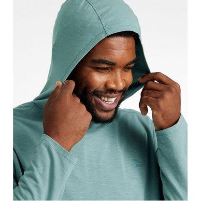A model wears the L.L.Bean Men's Regular Insect Shield Field Hoodie in Mineral Blue, adjusting the hood against a plain white background.