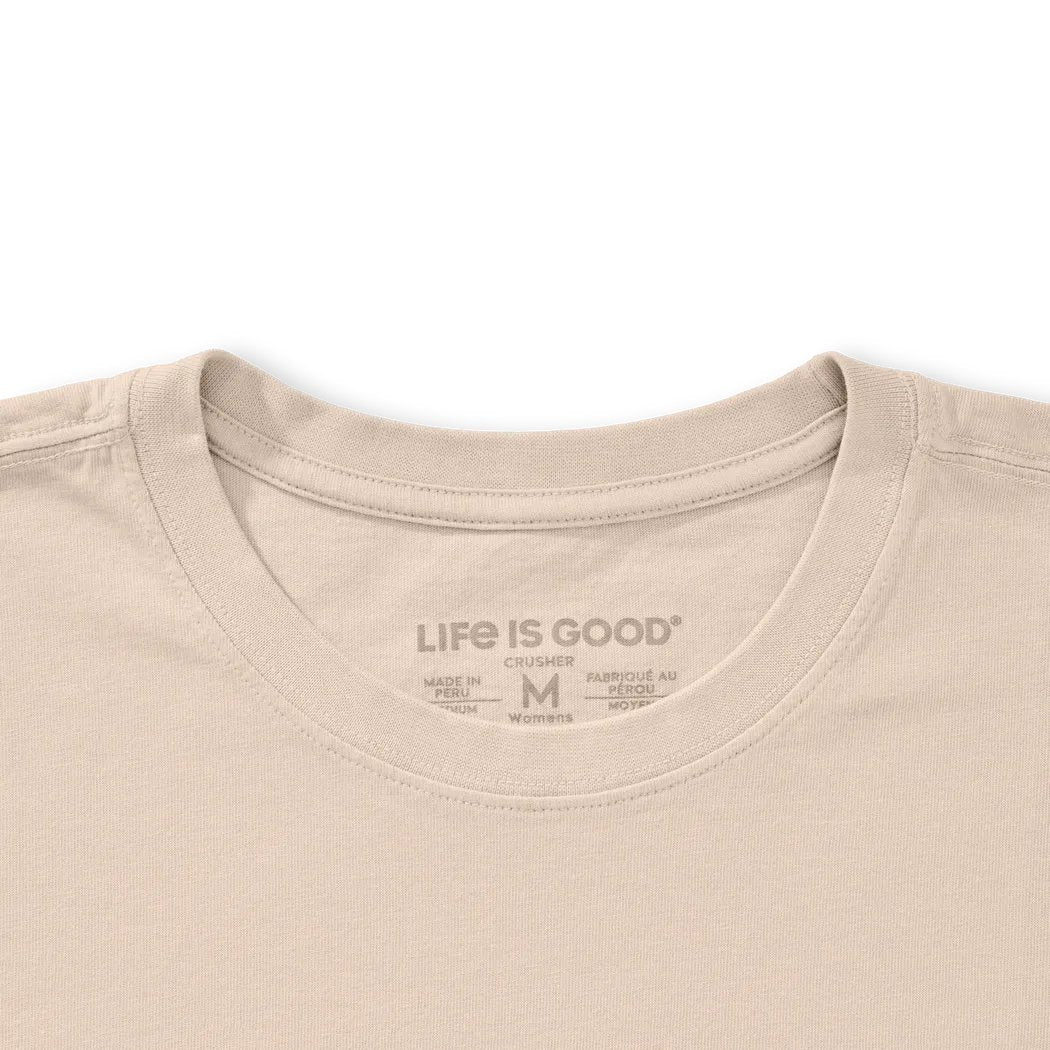A close-up of the Life is Good Women's Florowl Moon Short Sleeve Crusher Tee in Birch White showing the collar and tag against a white background.