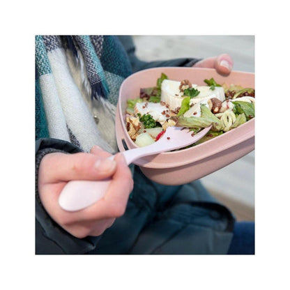A person in a Deeply Blue jacket holds a Light My Fire Spork Original BIO with a pink bowl of salad in the background.