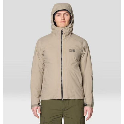 A front view of the Mountain Hardwear Men's Stretch Ozonic Insulated Jacket in Dunes with a hood, zippered front, and a model wearing olive pants against a light background.