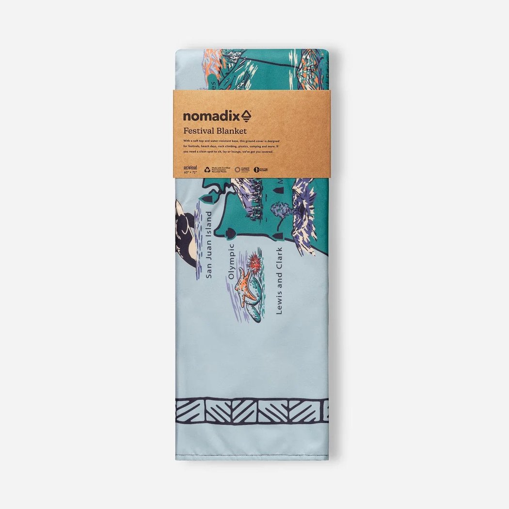 Front view of the Nomadix Festival Blanket in Baja Aqua showing the printed design and brown packaging against a white background.