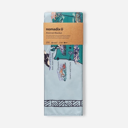 Front view of the Nomadix Festival Blanket in Baja Aqua showing the printed design and brown packaging against a white background.