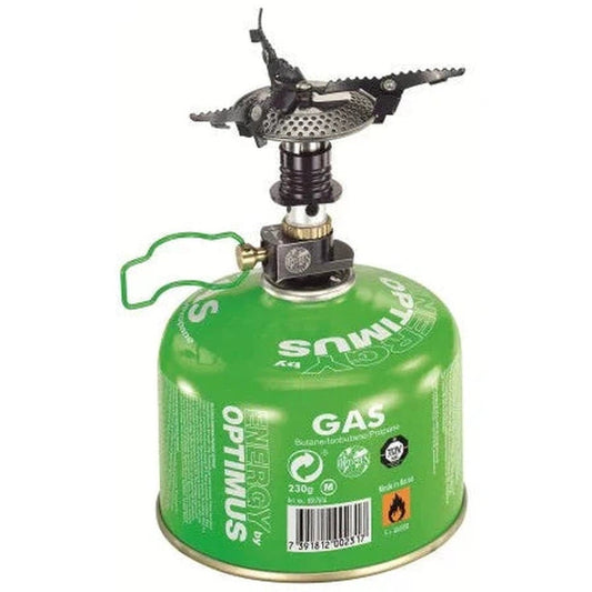 A green Optimus Crux camping stove with a black burner on top, shown from a front angle against a white background.