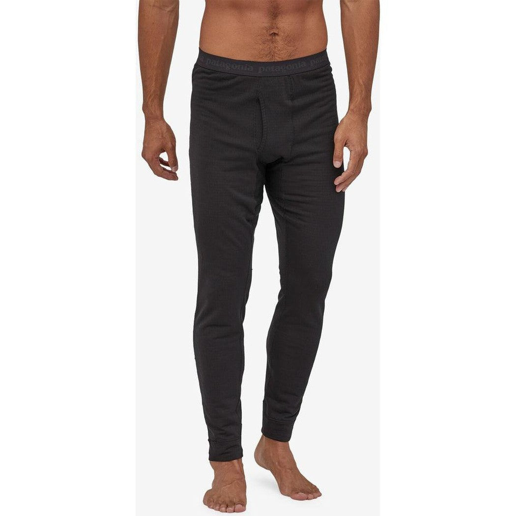 A front view of the Patagonia Men's Capilene Thermal Weight Bottoms in Black on a barefoot model against a white background.