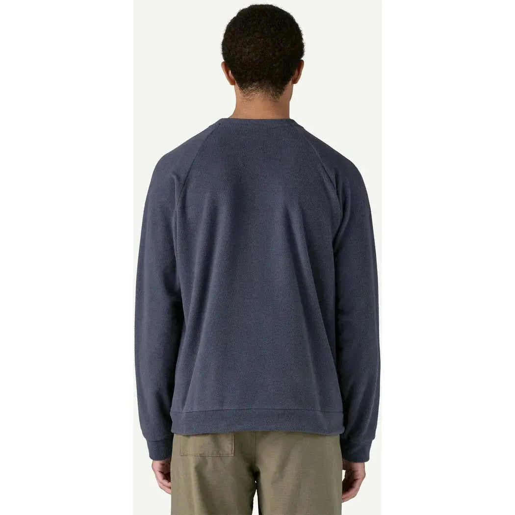 Back view of the Patagonia Men's Micro D Crewneck in Basin Green on a model wearing khaki pants against a plain white background.