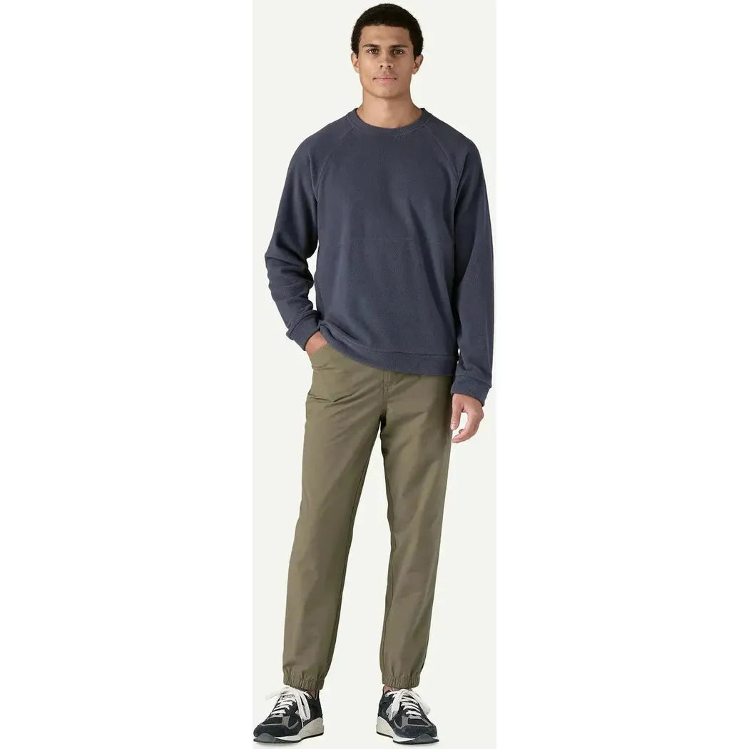A model wearing the Patagonia Men's Micro D Crewneck in Basin Green stands against a plain white background.