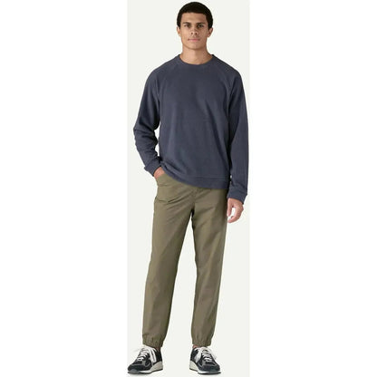 A model wearing the Patagonia Men's Micro D Crewneck in Basin Green stands against a plain white background.