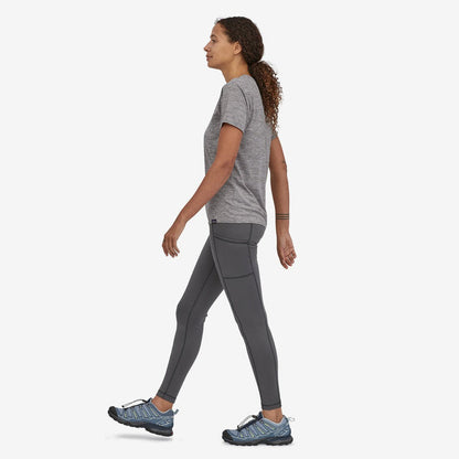 Side view of the Patagonia Women's Cap Cool Daily Shirt in Feather Grey showing the short sleeve and a woman wearing it against a white background.