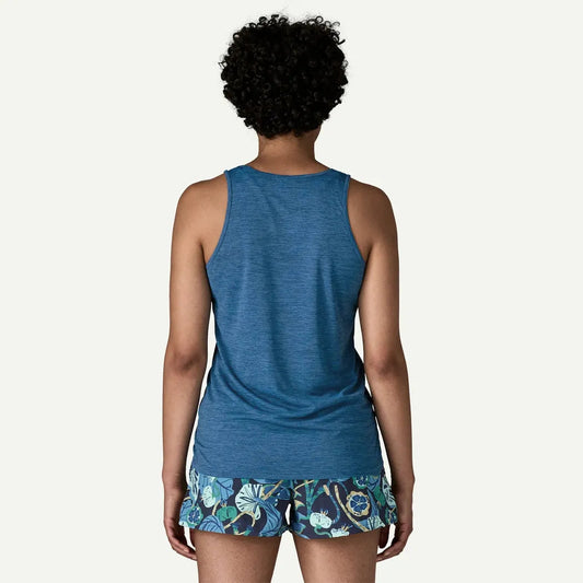 Back view of the Patagonia Women's Cap Cool Daily Tank in Aquatic Blue - Light Aquatic Blue X-Dye on a model wearing floral shorts against a white background.