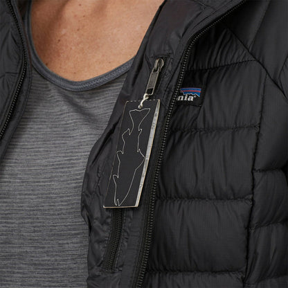 A close-up of the Patagonia Women's Down Sweater in Black, showing the zipper pull and logo on a model wearing it.