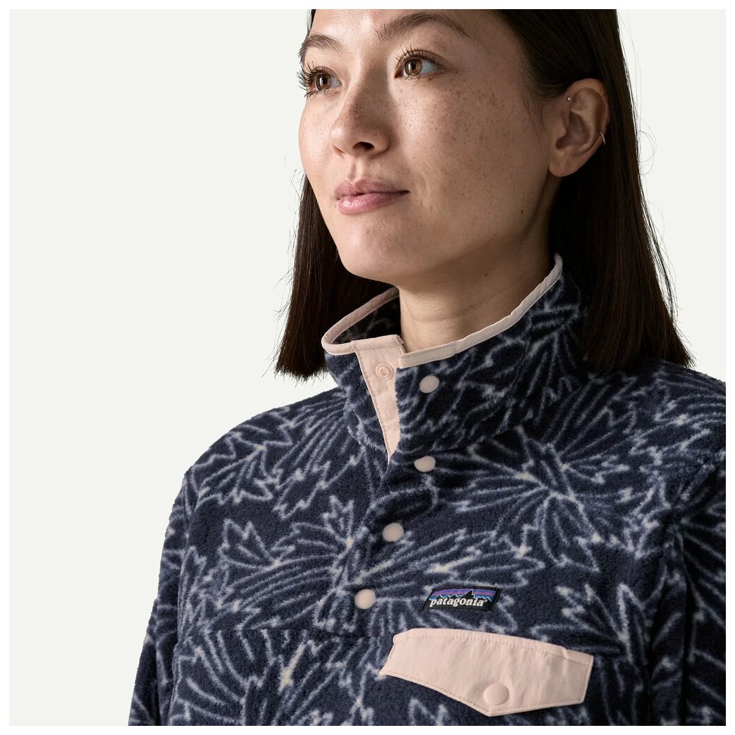 A woman wears the Patagonia Women's LW Synch Snap-T P/O in Sun Quilt Blue Sage, showing the snap-front and chest pocket against a plain background.