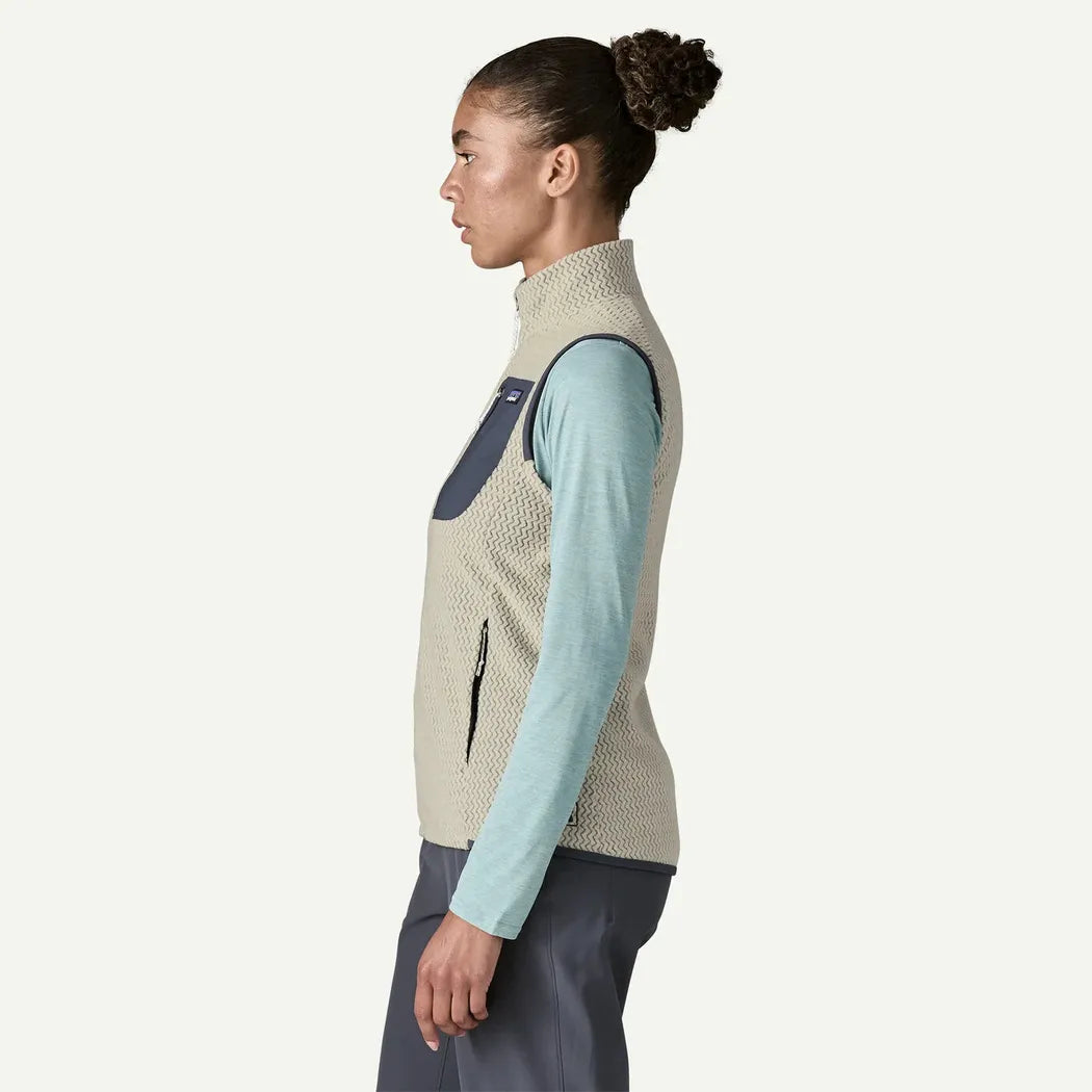 Side view of the Patagonia Women's R1 Air Vest in Wool White showing the zippered pocket and light blue long sleeve underneath against a plain white background.