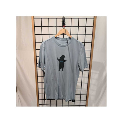Front view of the Prana Mens Bear Squeeze Journeyman SS Tee-SAMPLE in Glacier Sky hanging on a wooden hanger against a grid background.
