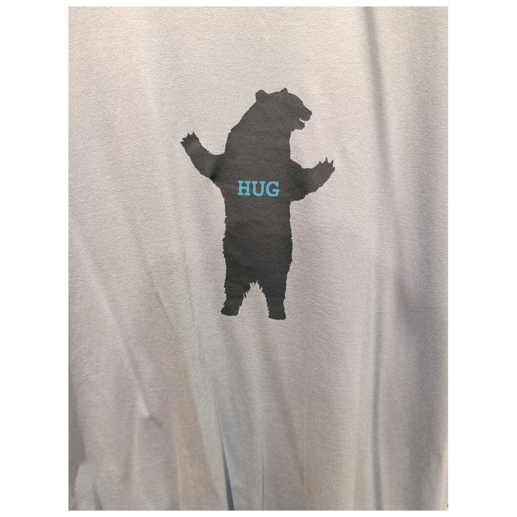 Front view of the Prana Mens Bear Squeeze Journeyman SS Tee-SAMPLE in Glacier Sky showing a bear silhouette with "HUG" on the chest against a light background.