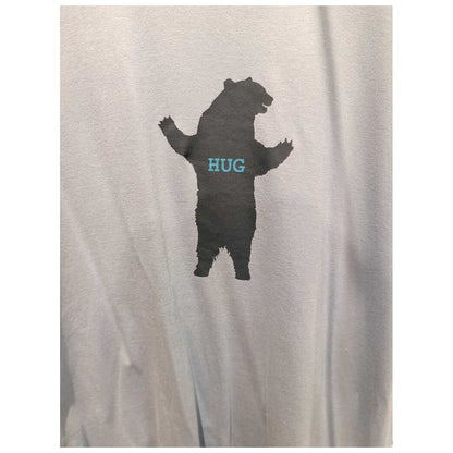 Front view of the Prana Mens Bear Squeeze Journeyman SS Tee-SAMPLE in Glacier Sky showing a bear silhouette with "HUG" on the chest against a light background.