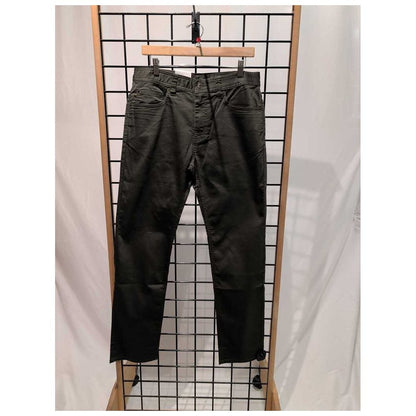 Front view of the Prana Mens Bridger Jeans-SAMPLE in Spruce/32 hanging on a grid display with a wooden frame.