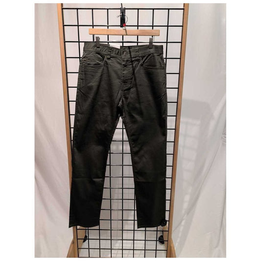 Front view of the Prana Mens Bridger Jeans-SAMPLE in Spruce/32 hanging on a grid display with a wooden frame.