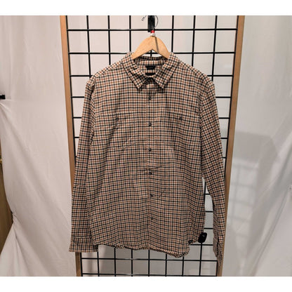 Front view of the Prana Mens Dolberg Flannel-SAMPLE in Tawny hanging on a wooden hanger against a grid background.