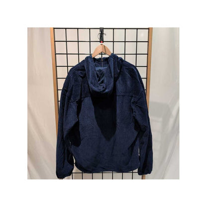 Back view of the Prana Mens Durado Cord Anorak-SAMPLE in Capulet Blue hanging on a grid display with a wooden hanger.