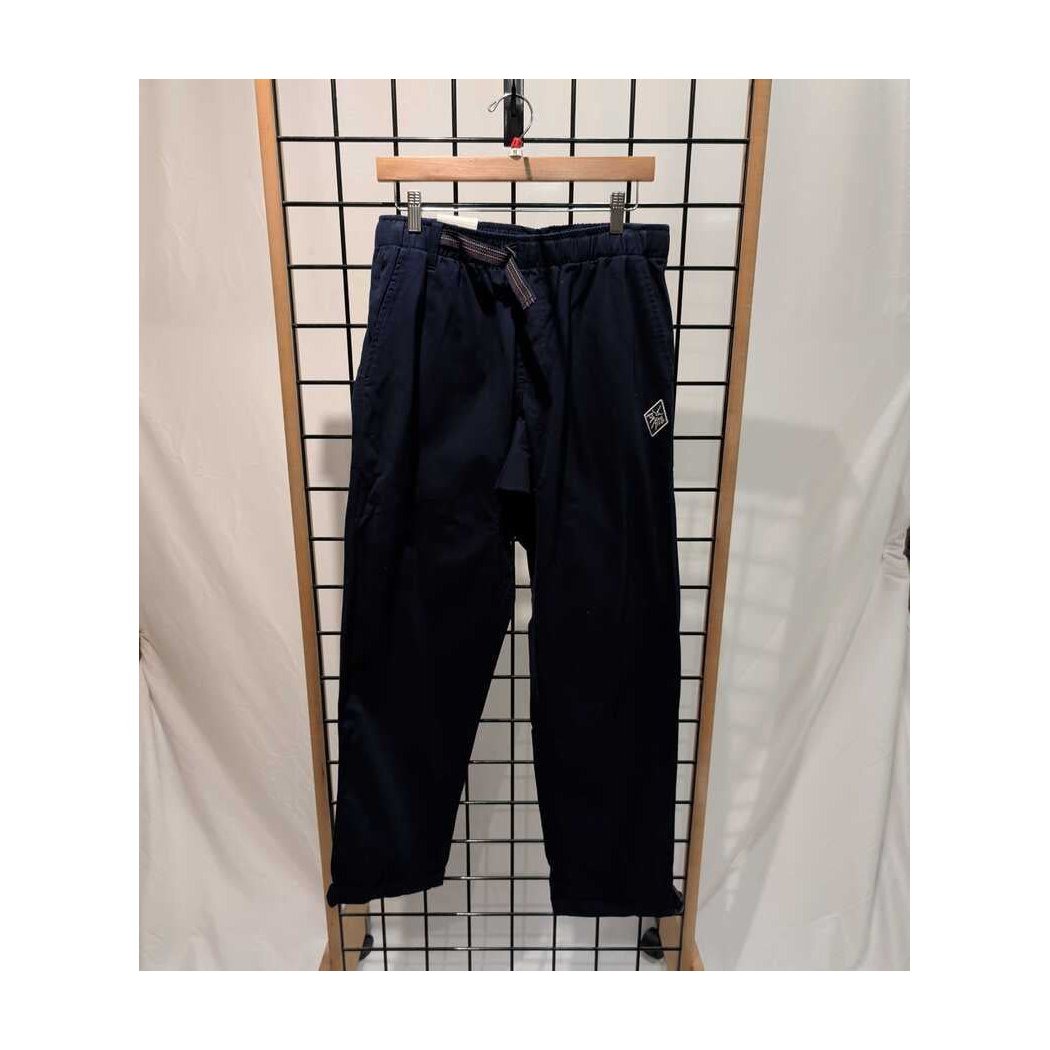Front view of the Prana Mens Durado Pant-SAMPLE in Capulet Blue hanging on a grid display with a wooden hanger.