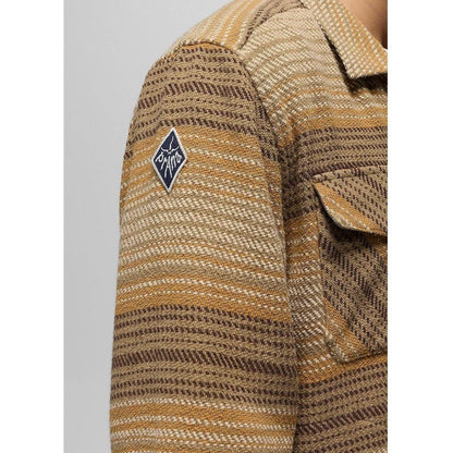 A close-up of the Prana Men's Heritage Zip Flannel in Dark Roast showing the shoulder patch and chest pocket against a light background.