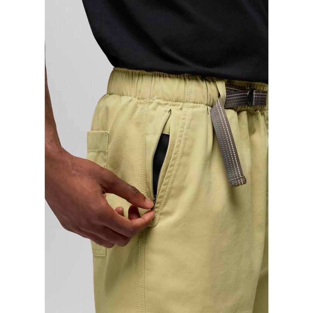 A close-up of the Prana Sample - Men's Durado Short in Jackfruit showing the front pocket and elastic waistband on a model wearing a black shirt against a light gray background.