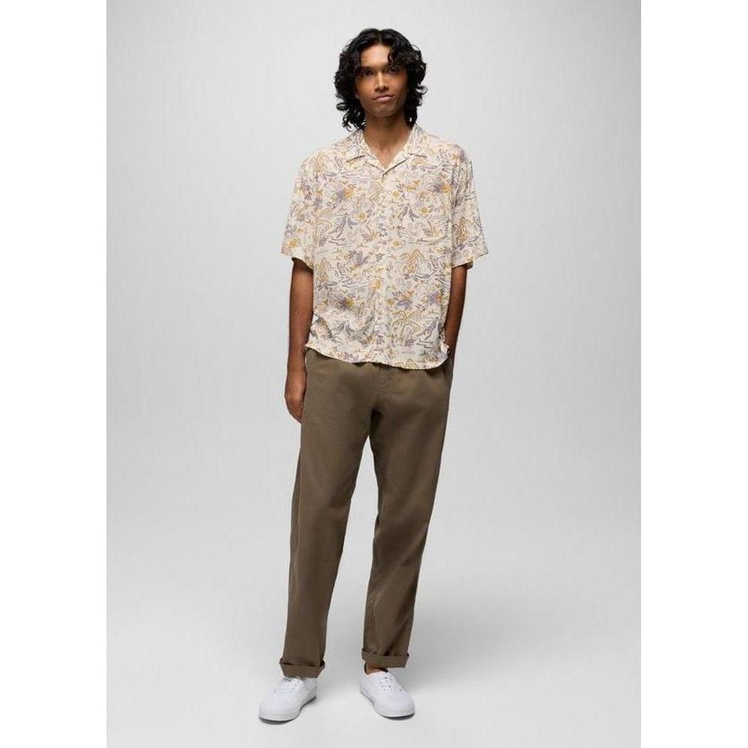 A model wearing the Prana Sample - Men's Peacepath Shirt in Beach Pebble Vacation stands against a plain gray background.
