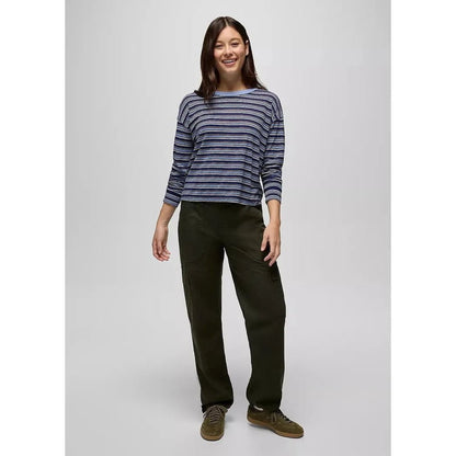 A woman wearing the Prana Women's Cozy Up Long Sleeve Crew in Capulet Blue Stripe stands against a plain background.
