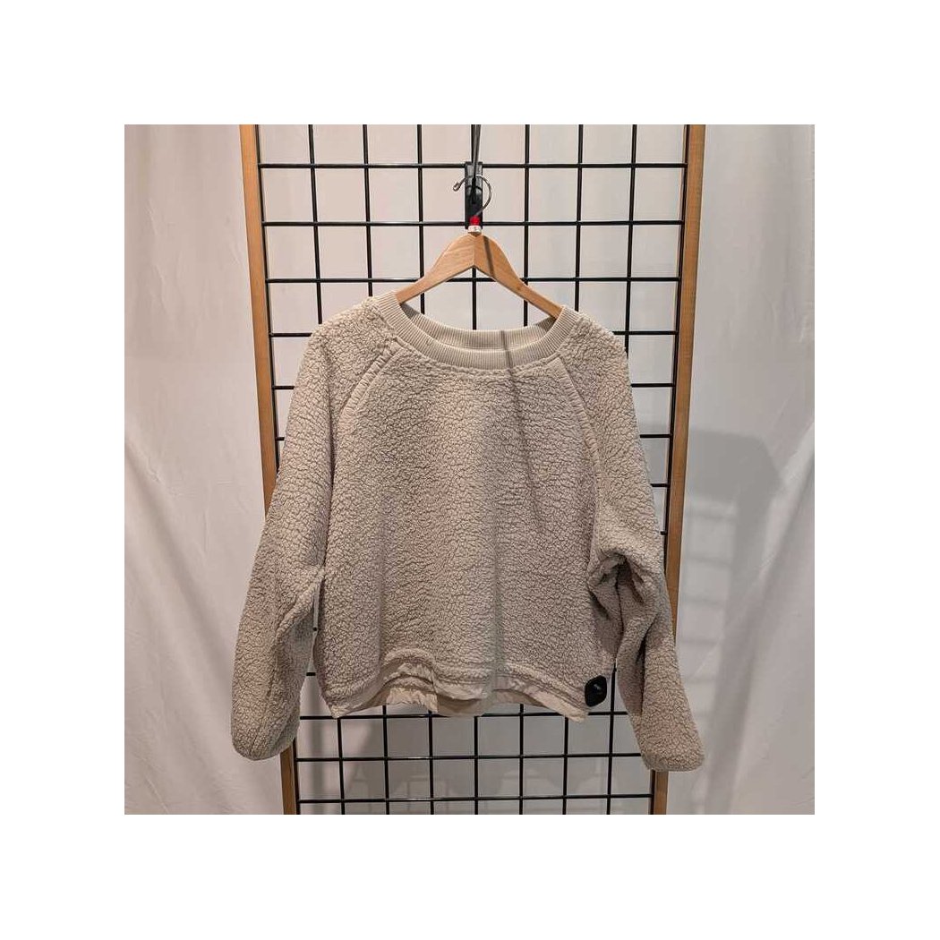 Front view of the Prana Womens Encinitas Sherpa Crew-SAMPLE in Almond hanging on a wooden hanger against a grid backdrop.