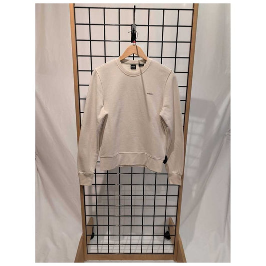 Canvas Prana Womens Everyday Crew Sweatshirt-SAMPLE hangs on a wooden hanger against a grid display with white drapes.
