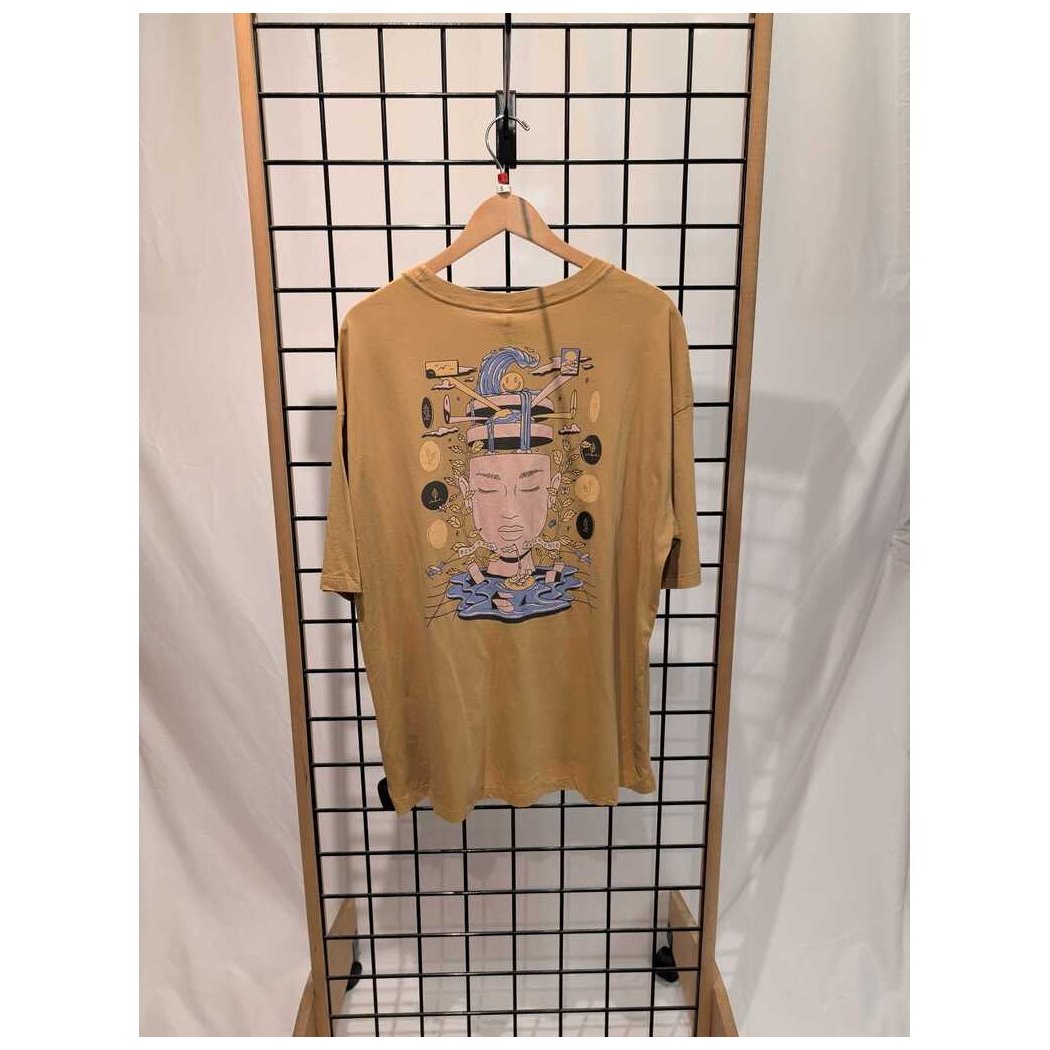 Front view of the Prana Womens Everyday Graphic Oversized Tee-SAMPLE in Dijon Vacation hanging on a grid display with a wooden frame.