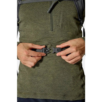 A close-up of the Rab Tygen 12 backpack in Black, showing a model fastening a belt buckle on their waist.