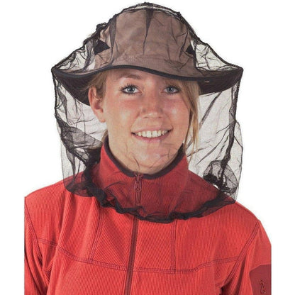 A woman wears the Sea To Summit Mosquito Head Net - Insect Shield with a black mesh and brown hat, against a white background.