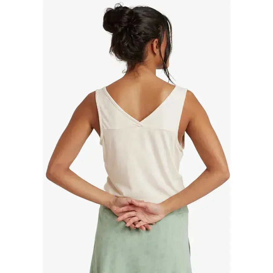 Back view of the Sherpa Adventure Gear Women's Bali V-Neck Tank in Peetho on a model with hands clasped behind her back against a white background.