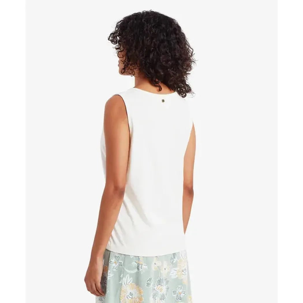 Back view of the Sherpa Adventure Gear Women's Kalindi Tank in Katha White on a model wearing a floral skirt against a white background.