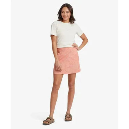 A model wearing the Sherpa Adventure Gear Women's Neha Skort in Rose Gold stands against a white background.