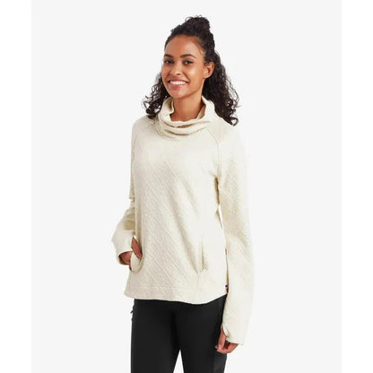 A woman wearing the Sherpa Adventure Gear Women's Nyano Pullover in Ecru stands against a plain white background.