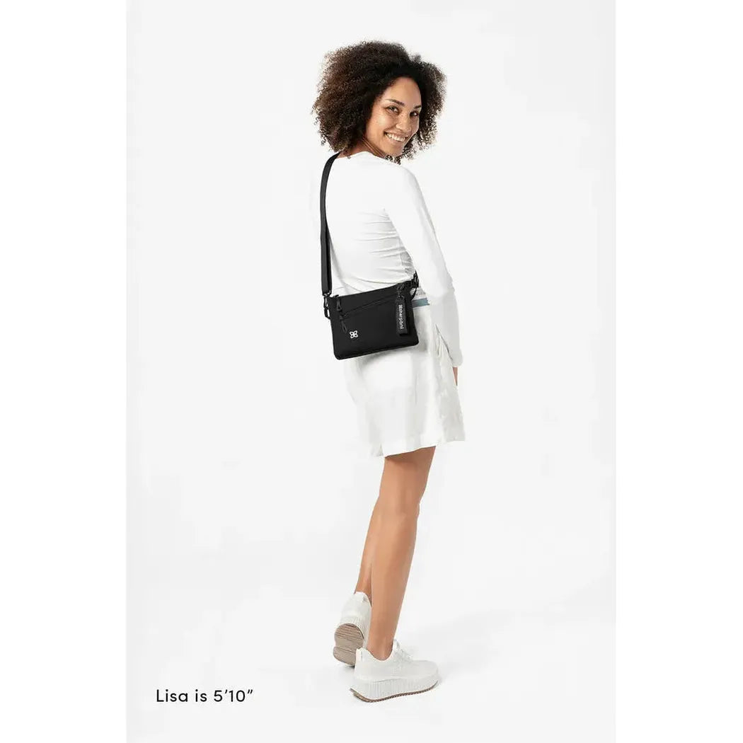 A model wearing the Sherpani Zoom Con Leche bag in a side view against a white background.