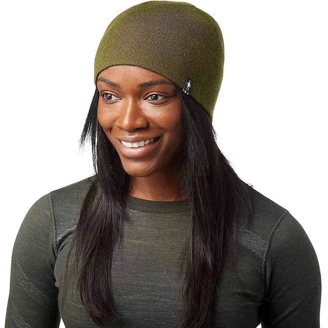 A woman wears the Smartwool The Lid in Winter Moss, a close-up front view with a plain white background.