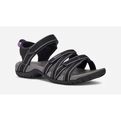 Side view of the Teva Women's Tirra in Black/Grey showing the adjustable straps and white stitching against a white background.