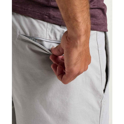 Side view of the Toad & Co Men's Mission Trek Chino Short in Basalt showing the zippered back pocket and model hand.