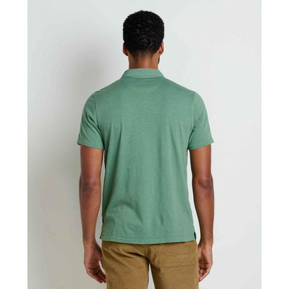 Back view of the Toad & Co Men's Primo Short Sleeve Polo in Ivy on a model wearing khaki pants against a plain white background.