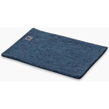 A flat lay photo of the Turtle Fur Comfort Stria Pipe Dream in Baltic color, showing the textured fabric and a small logo tag on the upper left corner against a white background.