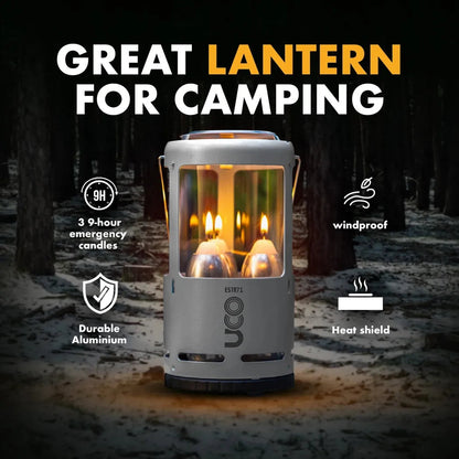 A front view of the UCO Candlelier Candle Lantern - Aluminum with its windproof and heat shield features visible against a snowy forest background.